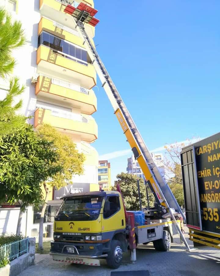 Dış cephe asansörü yüksek bloğun cephesine uzanmış hâlde — Bayraklı